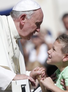 Pope greets a boy as he leaves general audience in St. Peter's Square at Vatican