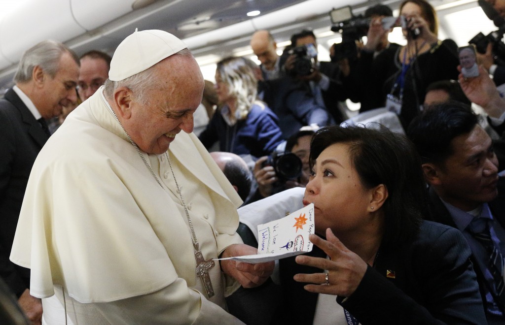 Pope Francis accepts card from Filipino reporter aboard flight to Colombo, Sri Lanka