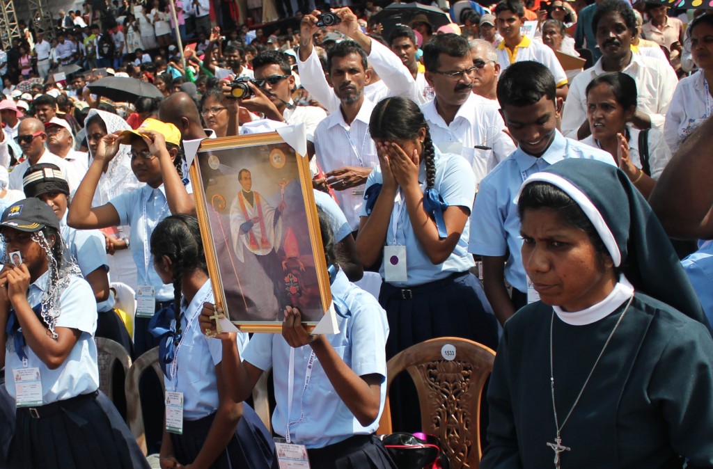 Young woman holds image of St. Joseph Vaz during canonization in Sri Lanka