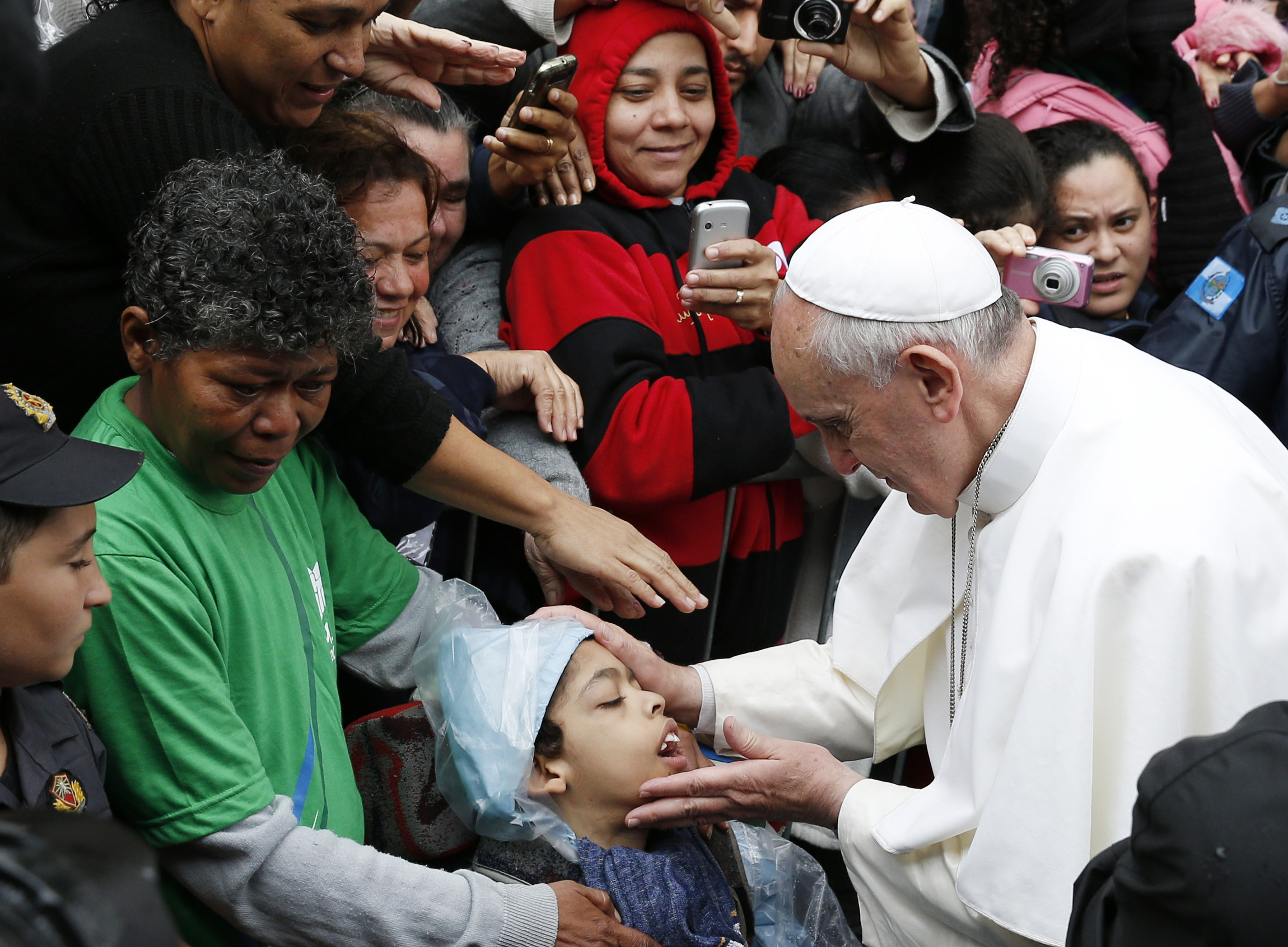 Pope Francis blesses boy during visit to slum complex in Brazil