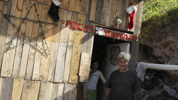Woman and girl stand outside home in poor neighborhood of Honduras