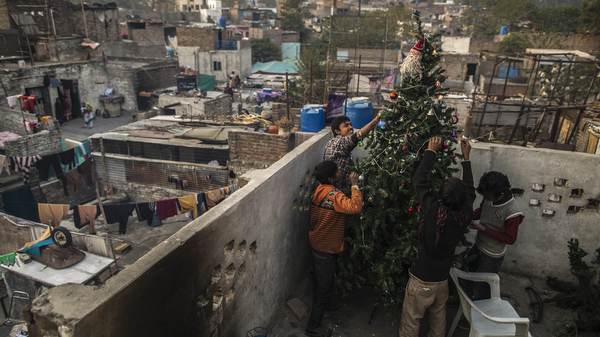 Pakistani boys decorate Christmas tree on roof of house in Islamabad