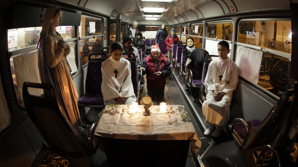 PEOPLE PRAY IN BUS DURING CHRISTMAS MASS FOR HOMELESS IN FRANCE
