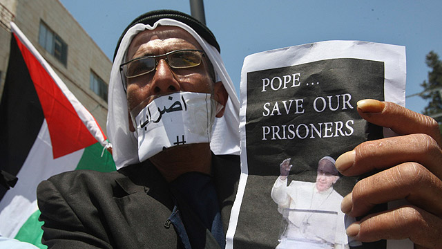 A Palestinian man holds a picture of Pope Francis during a May 24 demonstration calling for the release of Palestinian prisoners from Israeli jails and in solidarity with prisoners who have been on hunger strike for 31 days in Tulkarm, West Bank. (CNS photo/Abed Omar Qusini, Reuters) 