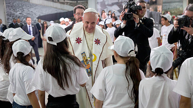 Pope Francis is greeted by young people during a meetingMay 25 in the Dehiyshe Refugee Camp's Phoenix Cultural Center, near Bethlehem, West Bank. Pope Francis told Palestinian refugee youths to look to the future and to always work and strive for the thi ngs they wanted. (CNS photo/Andrew Medichini, pool via Reuters)