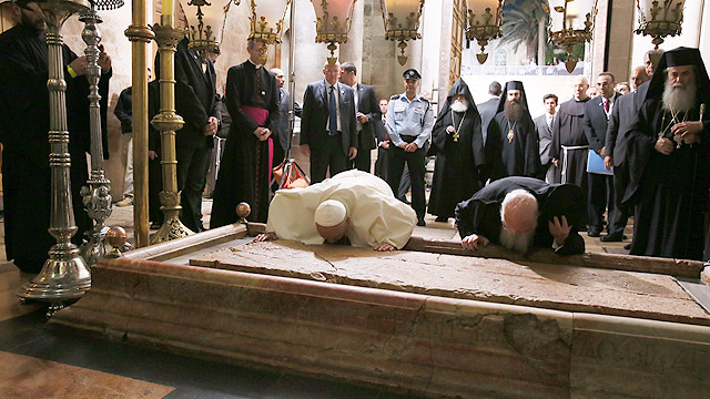 Pope Francis and Ecumenical Patriarch Bartholomew of Constantinople kiss the Stone of Unction in Jeusalem's Church of the Holy Sepulcher May 25. The two leaders marked the 50th anniversary of the meeting in Jerusalem between Pope Paul VI and Patriarch At henagoras. (CNS photo/Grzegorz Galazka, pool)