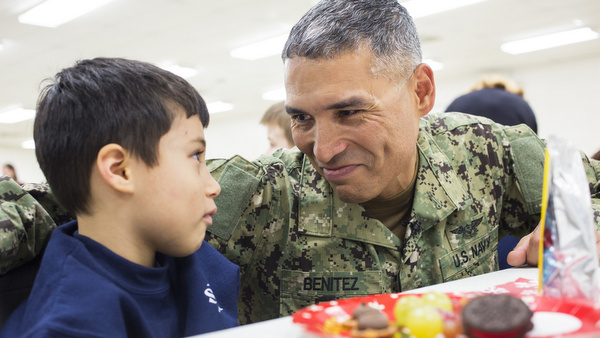 Navy Reserve Petty Officer Jesus Benitez talks with his son, Maddox, after surprising him and his sister, Mia, at St. Joan of Arc School in Aberdeen, Md., Dec. 18. His children did not know he was able to come home for the holidays. Benitez is in the middle of a yearlong deployment in Djibouti, on the Horn of Africa, where he expected to be celebrating Christmas this year. (CNS photo/Tom McCarthy Jr.) See BENITEZ Dec. 23, 2014.