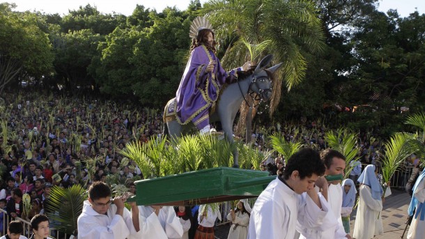 Pilgrims carry statue of Christ on donkey during Palm Sunday procession outside cathedral in Paraguay