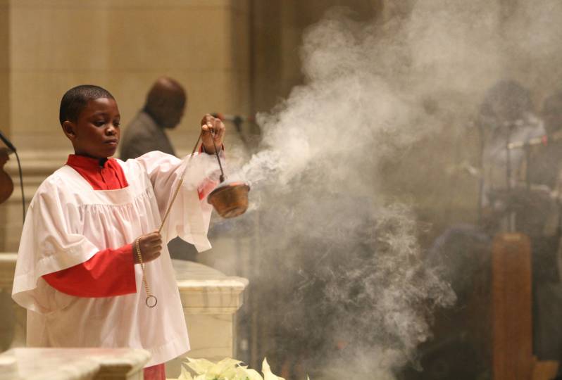 Altar server uses incense during Mass