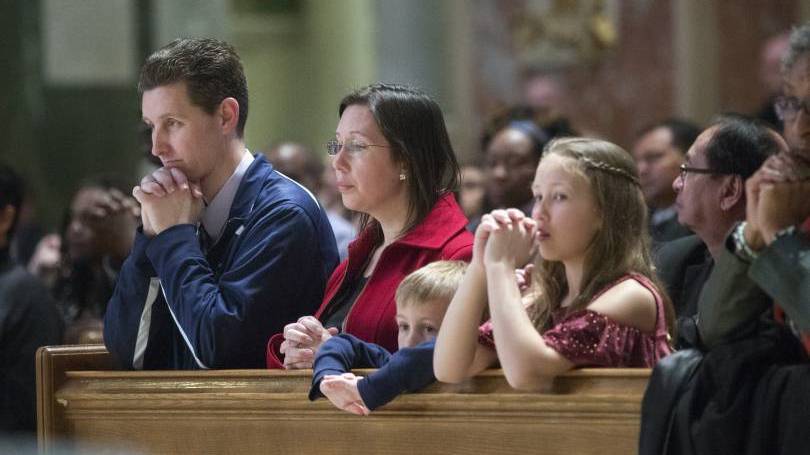 A family kneels during Mass