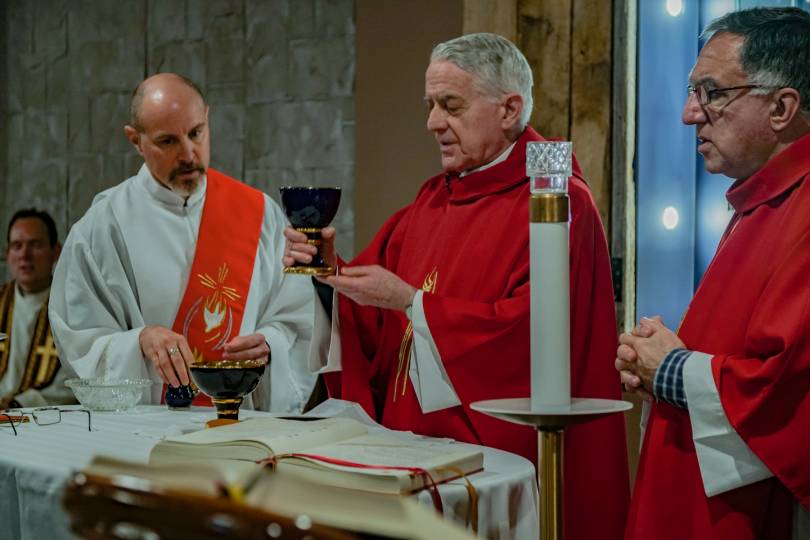 Two priests and a deacon during the preparation of the gifts at Mass