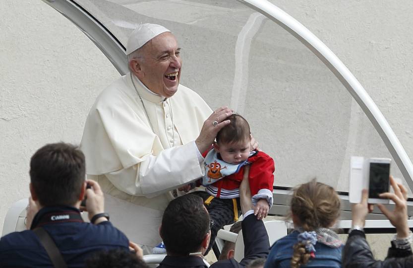 Pope Francis smiles as a papal security guard holds up a baby during his general audience in St. Peter's Square at the Vatican April 18. (CNS photo/Paul Haring)