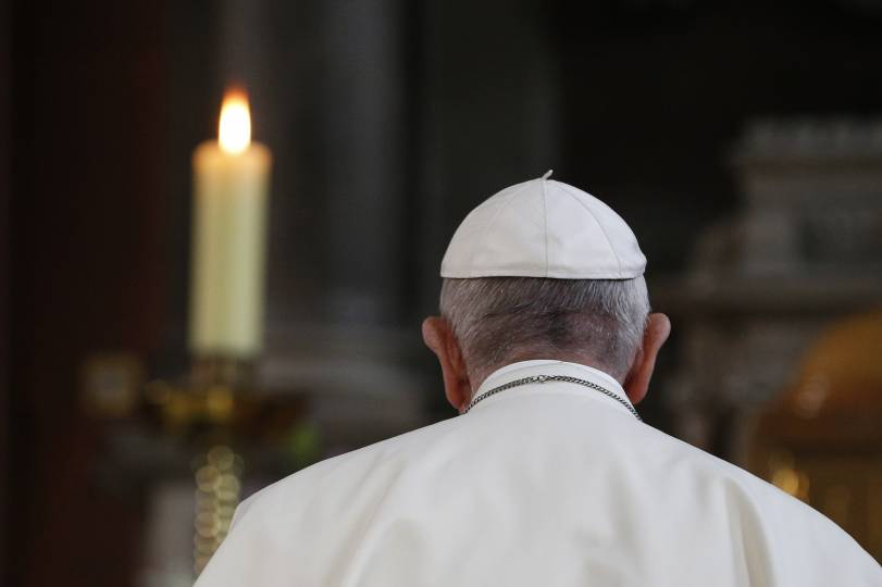 Pope Francis prays in front of a candle in memory of victims of sexual abuse as he visits St. Mary's Pro-Cathedral in Dublin Aug. 25. (CNS photo/Paul Haring)