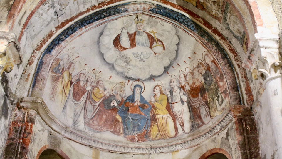 Curved church ceiling (apse) painted with depiction of God enthroned in a cloud sending the tongues of fire of the Holy Spirit on Mary and the Apostles.