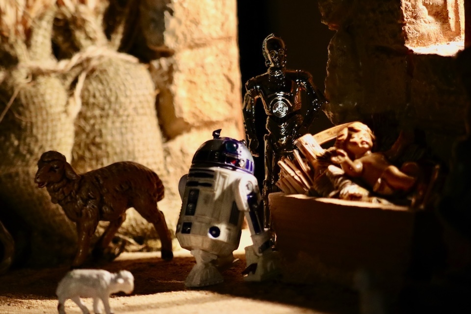 More action figures look on Jesus in the manger.