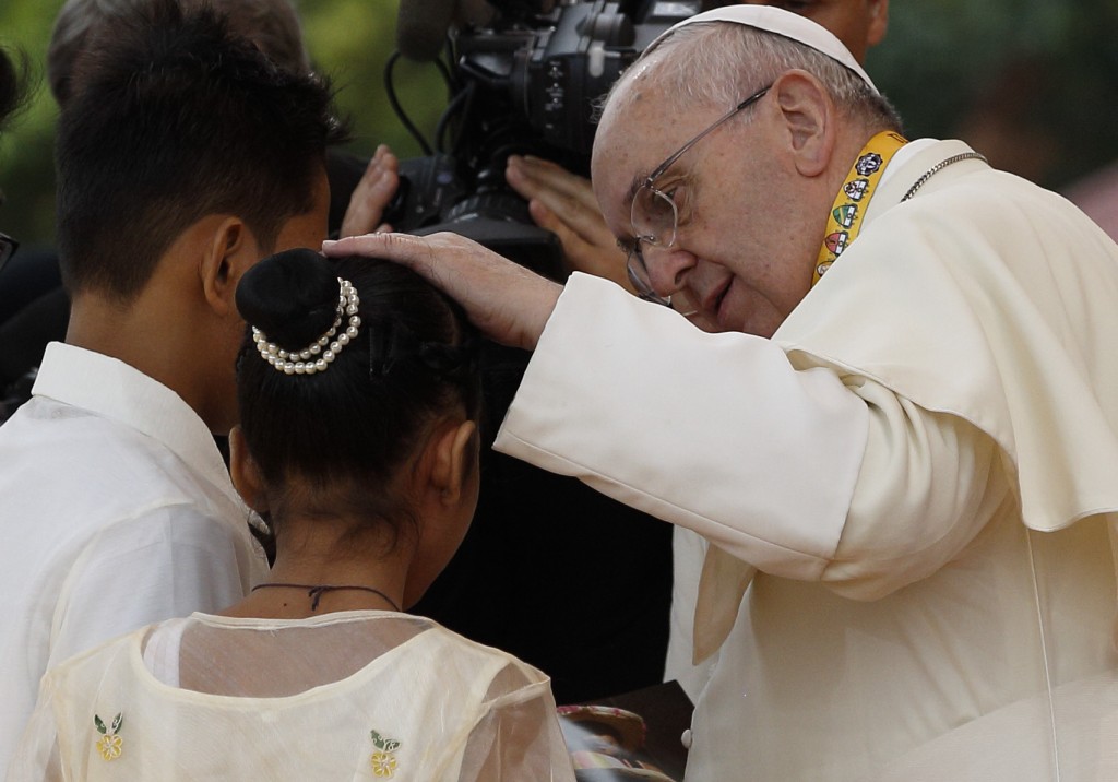 Pope Francis comforts former street child who spoke during meeting with young people at university in Manila