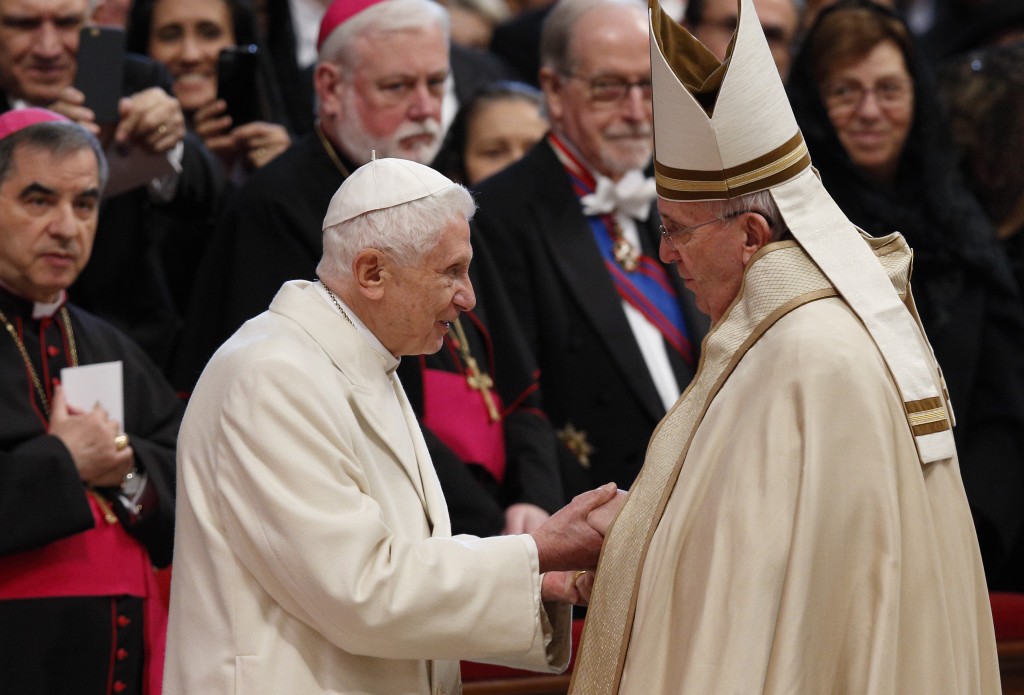 Retired Pope Benedict XVI and Pope Francis exchange greetings at conclusion of consistory at which Pope Francis created 20 new cardinals in St. Peter's Basilica at Vatican