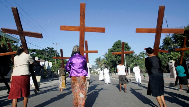 CATHOLIC WOMEN CARRY WOODEN CROSSES DURING PALM SUNDAY PROCESSION