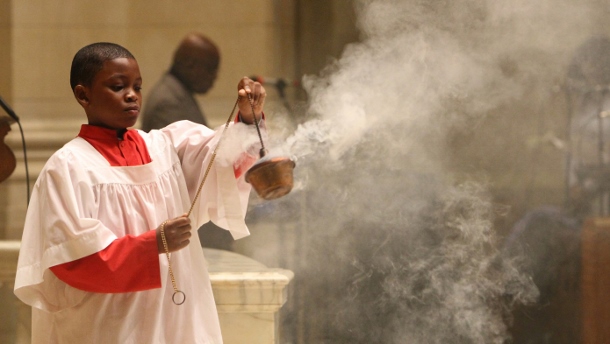 Altar server uses incense during French-language Mass at New York church for 17 victims of the recent terror attacks in France