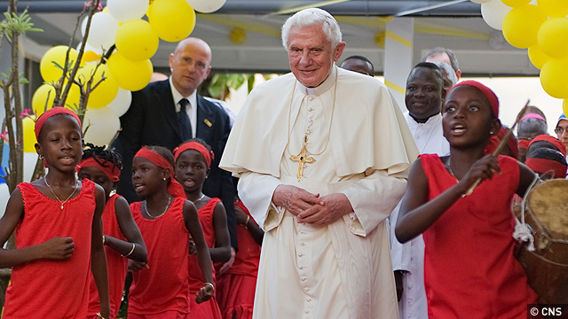 Pope Benedict XVI is surrounded by children dancing and singing as he arrives during his visit to St. Rita church in Cotonou